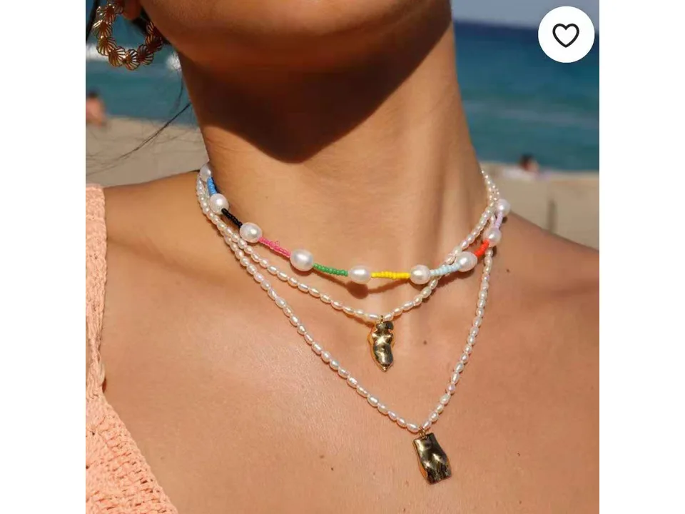 Model wearing the rainbow baroque pearl choker necklace layered with other pearl necklaces.