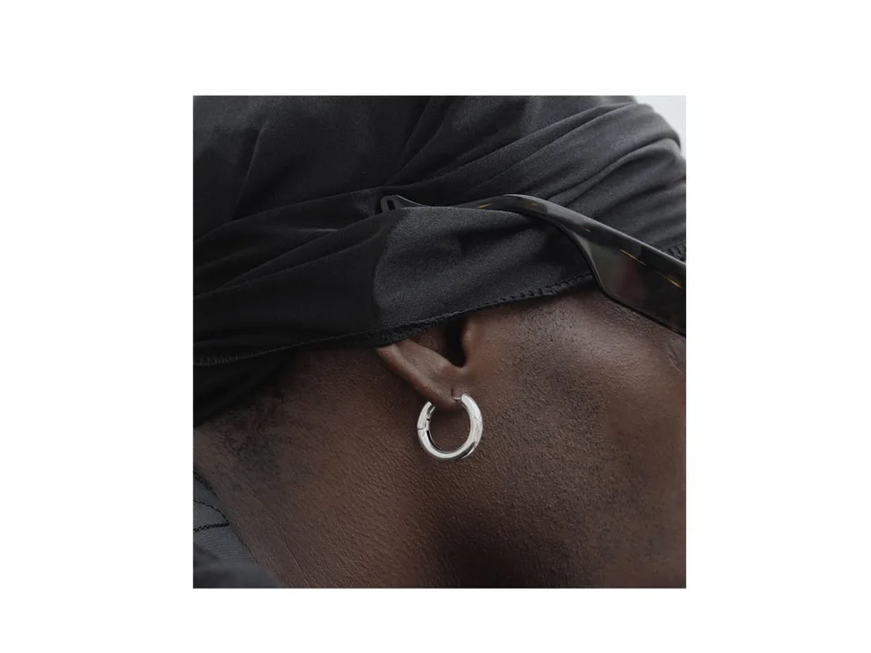 A person wearing a silver hoop earring.