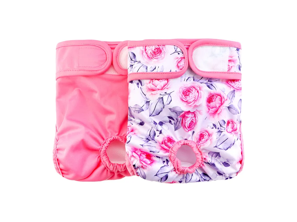 Two pink dog diapers, one solid and one with a floral rose pattern.
