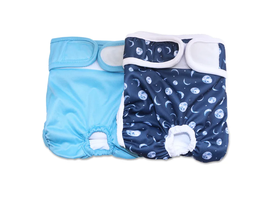 Two blue dog diapers, one solid and one with a moon and star pattern.