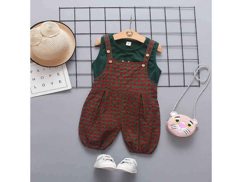 Green sleeveless top and red-green plaid bib overalls set with a straw hat and small pink purse.