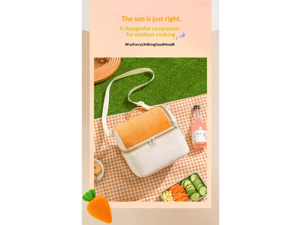 A plush lunch bag sitting on a picnic blanket with food items nearby.