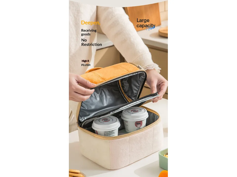 A person opening a plush insulated lunch bag to reveal the interior space.