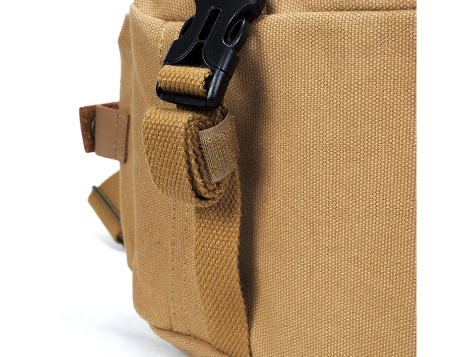 Close-up of the black plastic buckle and canvas strap on the side of the bag.