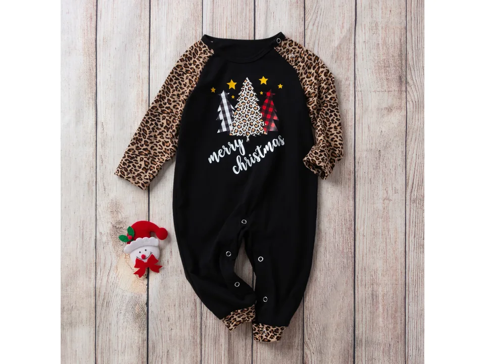 Children's Christmas jumpsuit with leopard print sleeves laid flat on a wooden background.