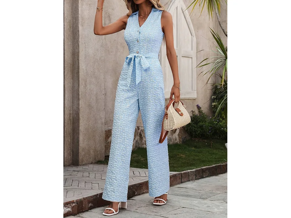 A model posing in a light blue sleeveless jumpsuit with a tie waist.