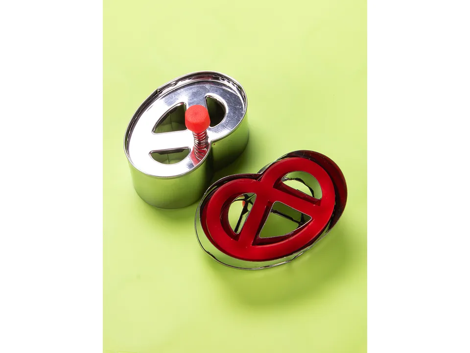 Two pretzel-shaped cookie cutters, one showing the top with a spring and one showing the underside.