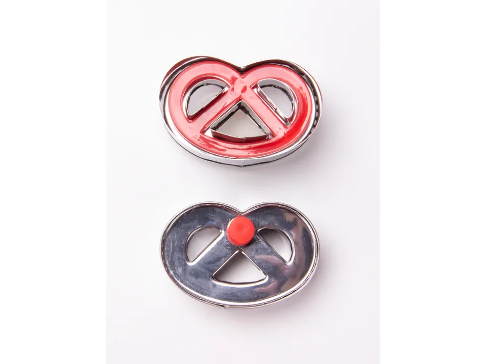Two pretzel-shaped cookie cutters, one red and one silver, on a white background.