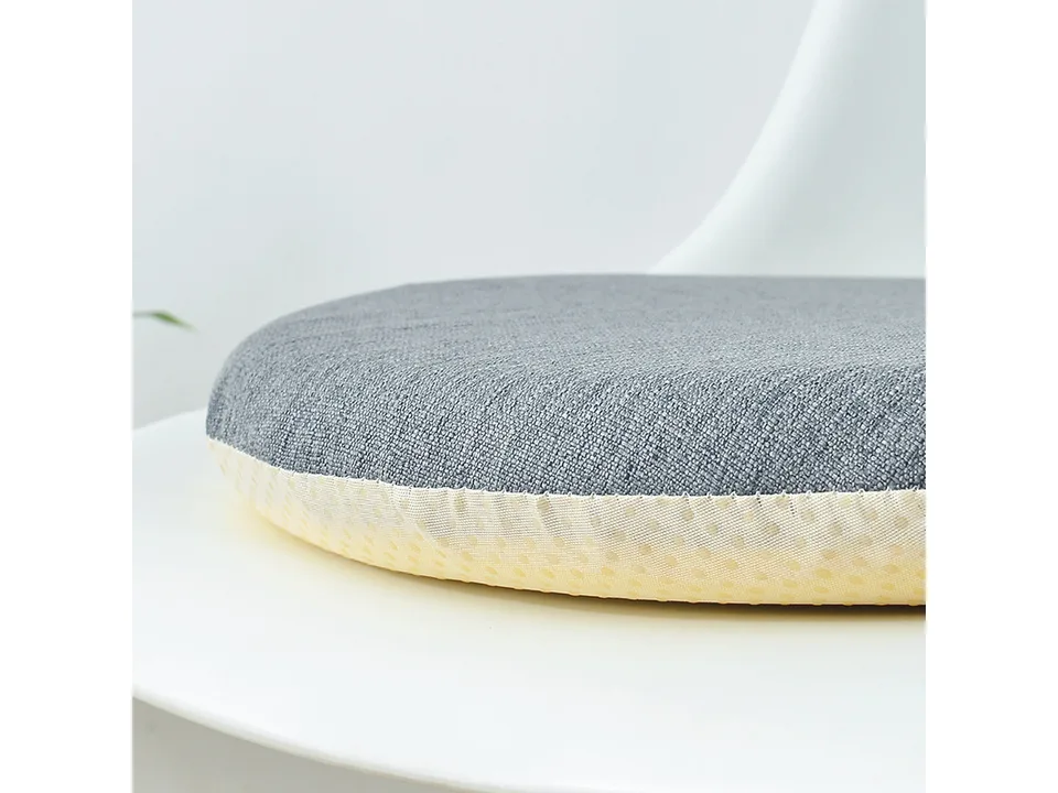 Close-up of a grey round chair cushion showing the fabric texture and dotted non-slip base.