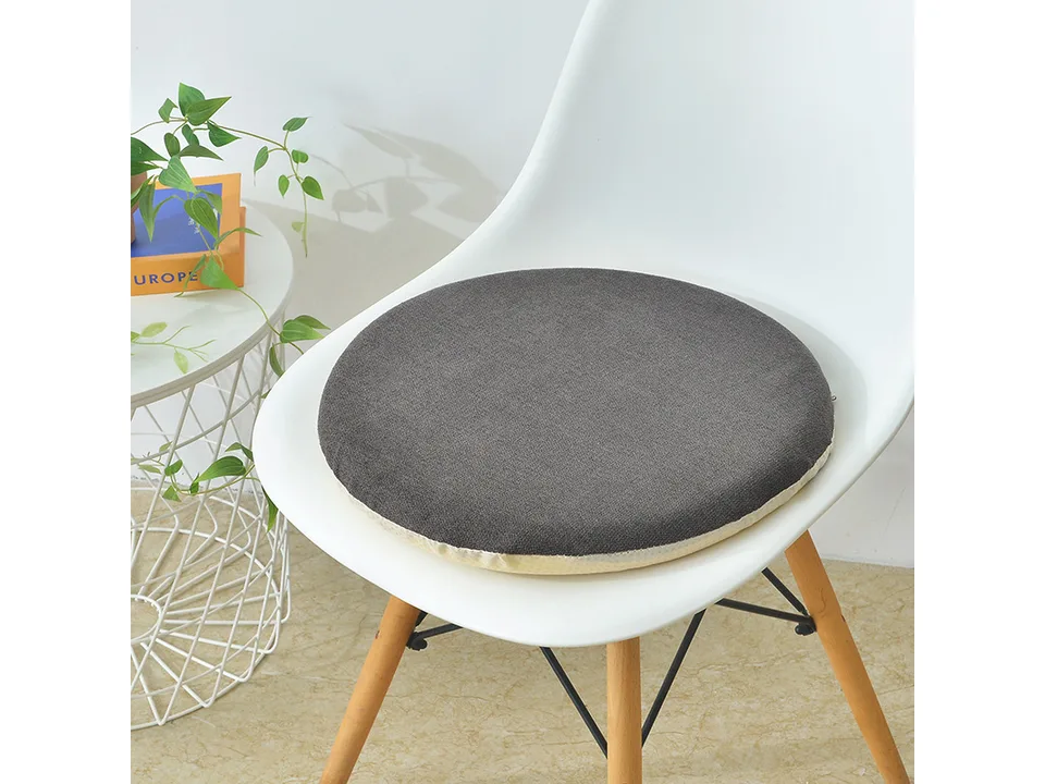 A grey round chair cushion placed on a white dining chair.
