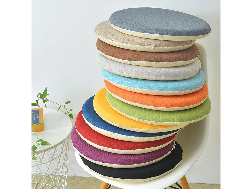 A stack of round chair cushions in various colors on a white chair.