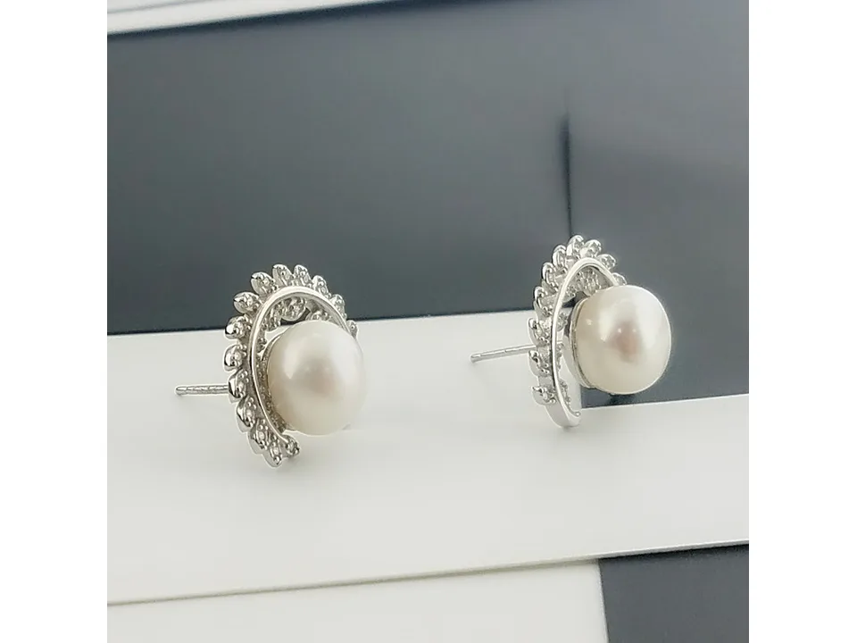 A pair of silver leaf-shaped stud earrings with a central pearl.