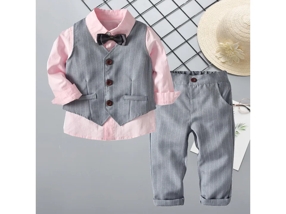 A boys formal suit set including a pink shirt, grey striped vest, grey striped trousers, and a bow tie.