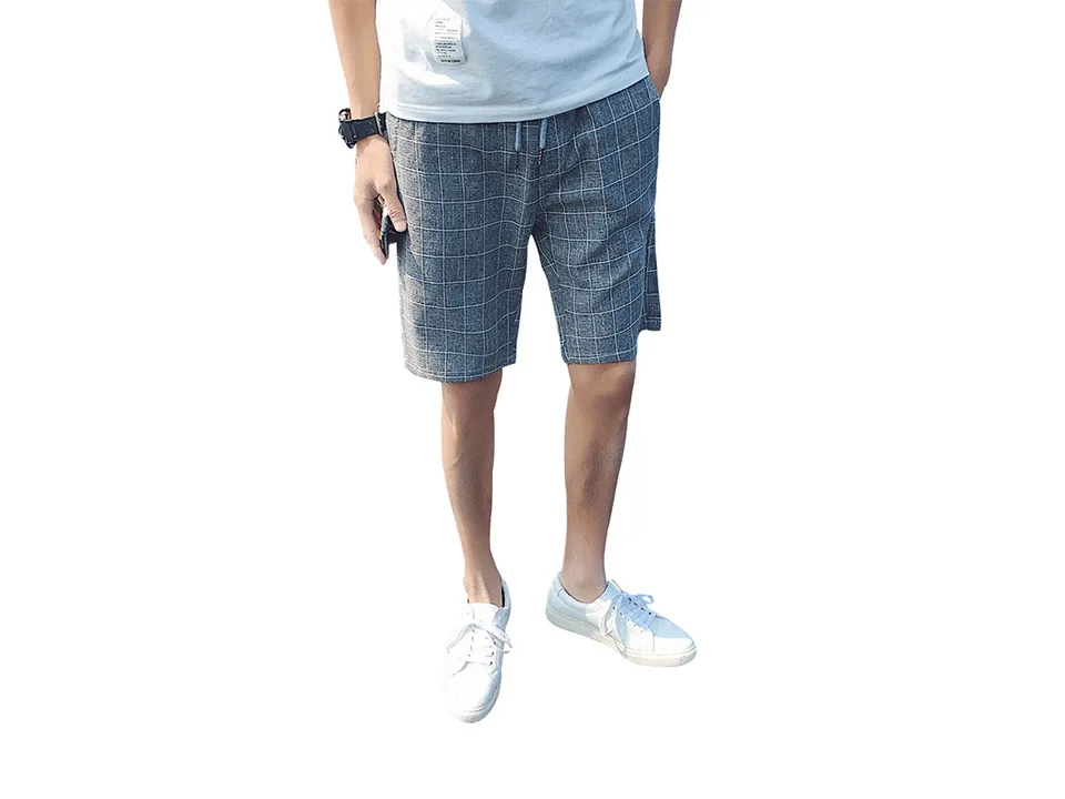 Man wearing grey plaid casual shorts with a white t-shirt.