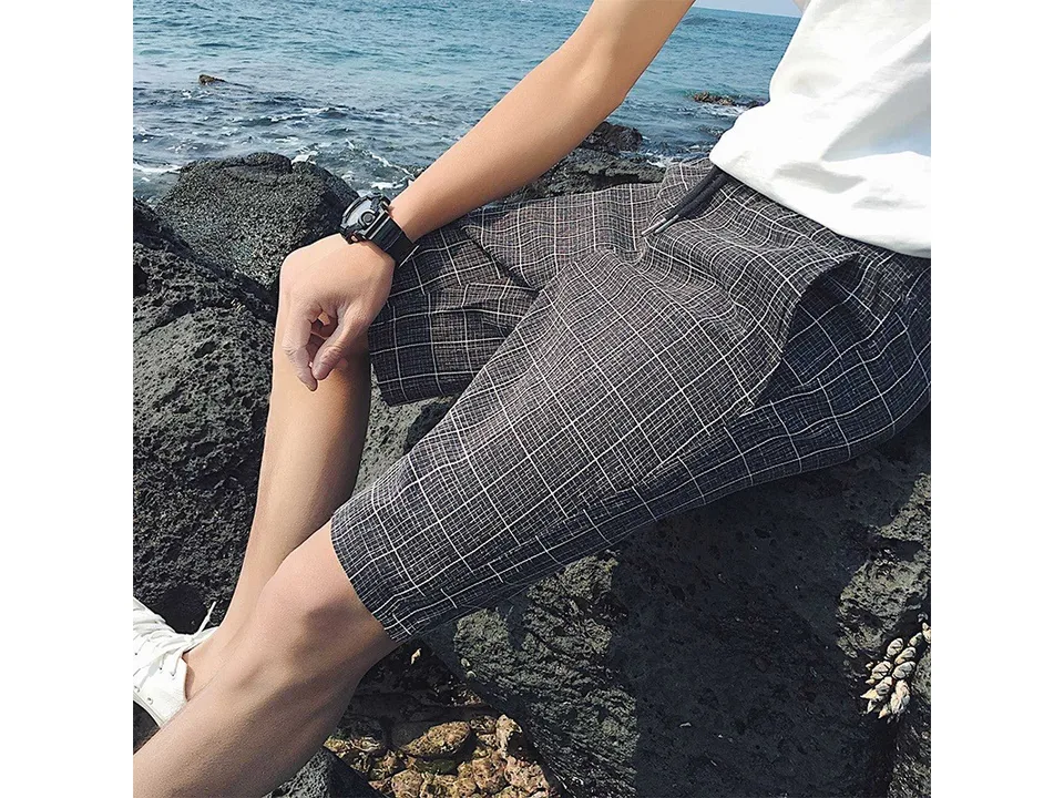 Close-up view of dark grey plaid shorts showing the fabric texture and drawstring.