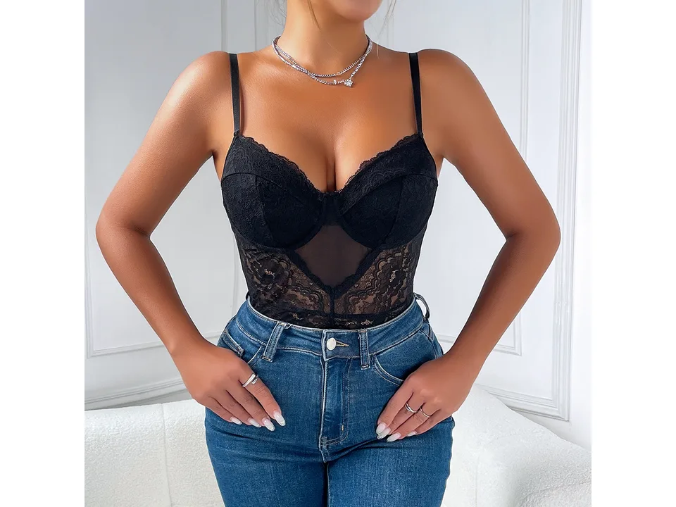 A woman wearing a black lace bodysuit tucked into blue jeans.