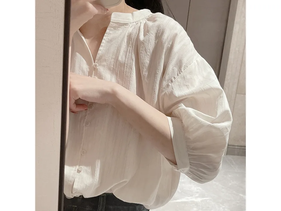 Close-up of the puff sleeve and fabric texture of the white shirt.