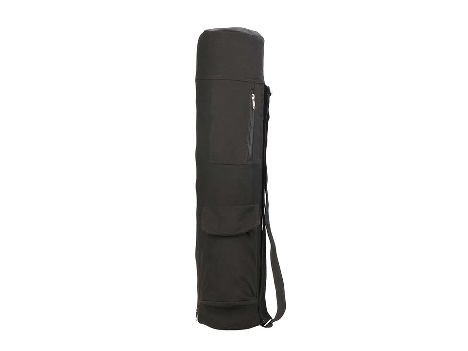 Black yoga mat bag standing upright, showing side pockets and shoulder strap.