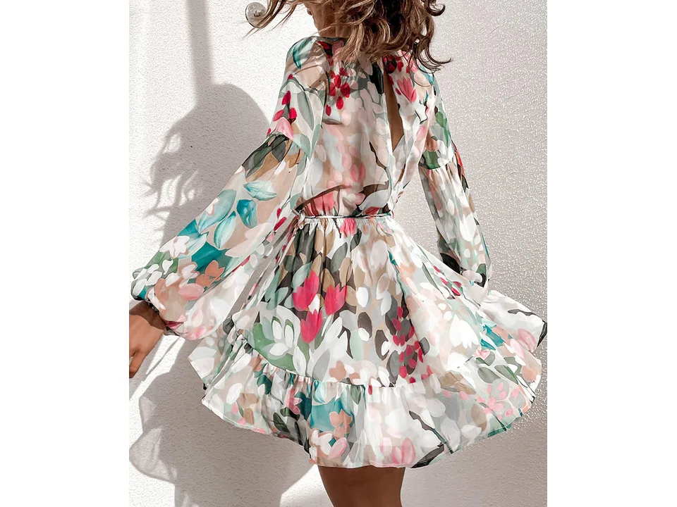 A woman wearing a floral V-neck chiffon mini dress, showing the back design.