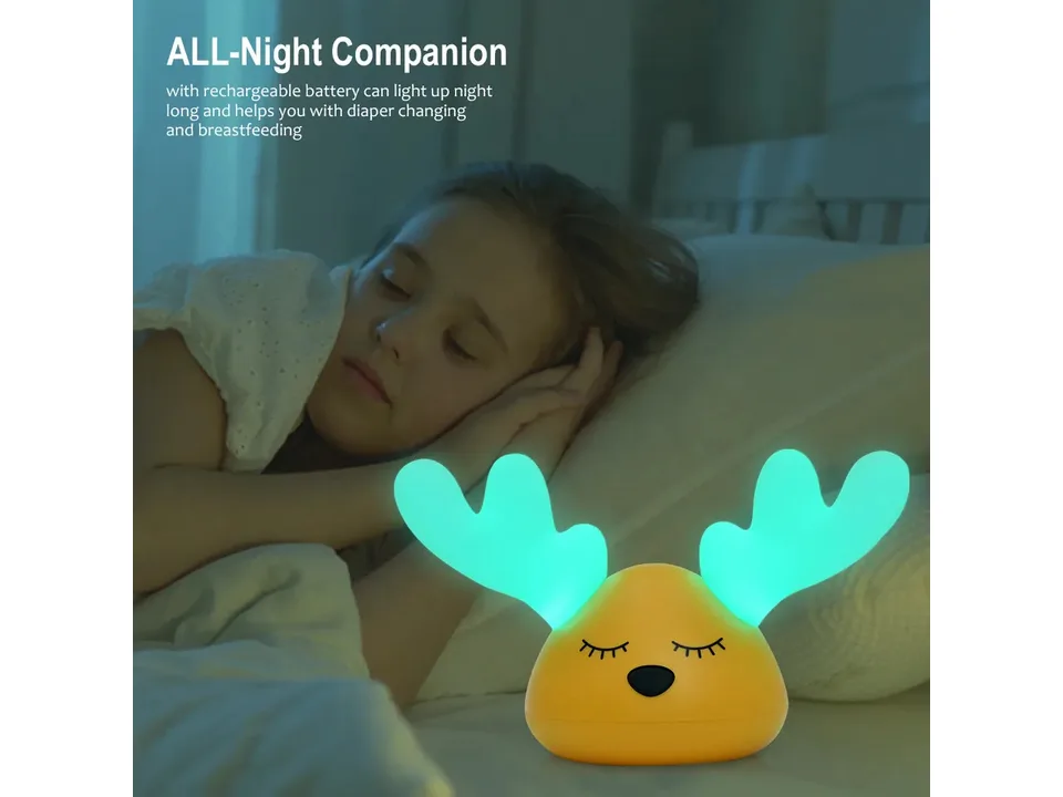 A child sleeping next to the glowing deer night light.