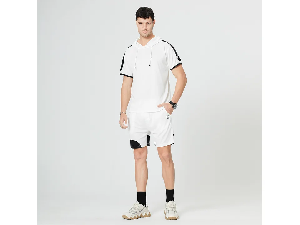 A man wearing a white short-sleeve hooded t-shirt and matching athletic shorts.
