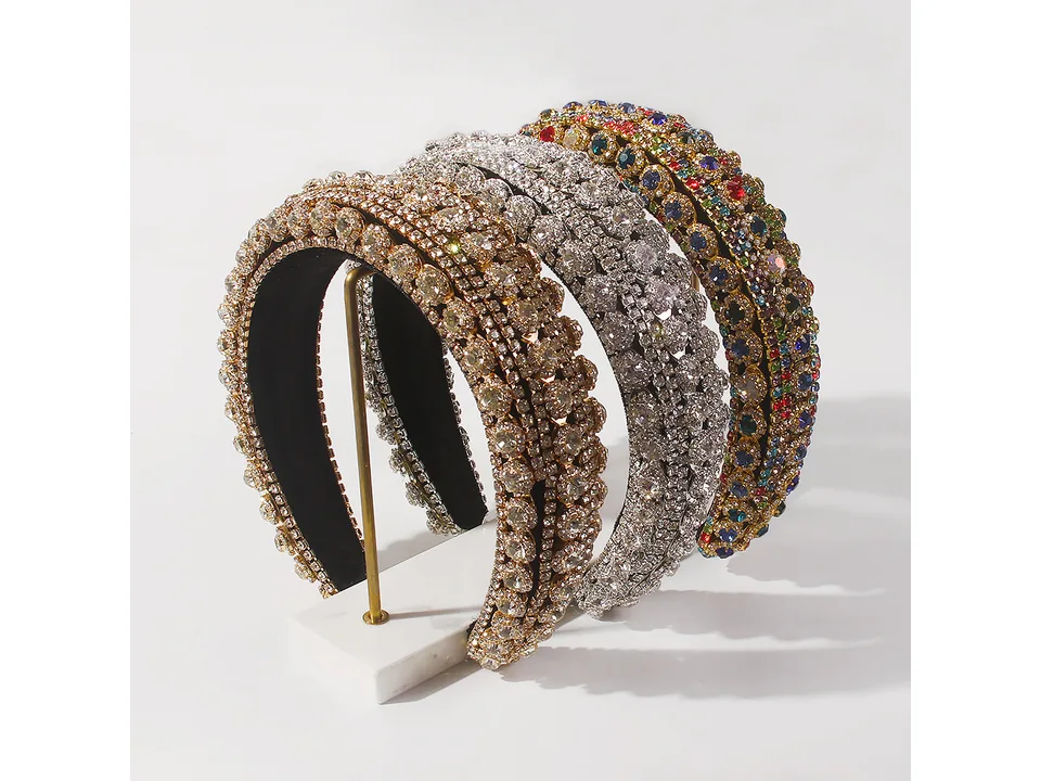 Three different rhinestone headbands displayed on a stand
