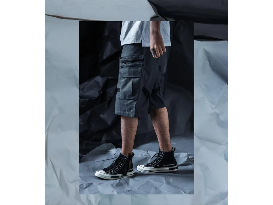 Side view of a person wearing the grey cargo shorts, showing the pocket and leg strap detail.