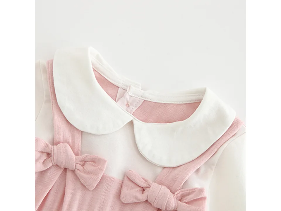 Close-up of the Peter Pan collar and bow details on the baby jumpsuit.