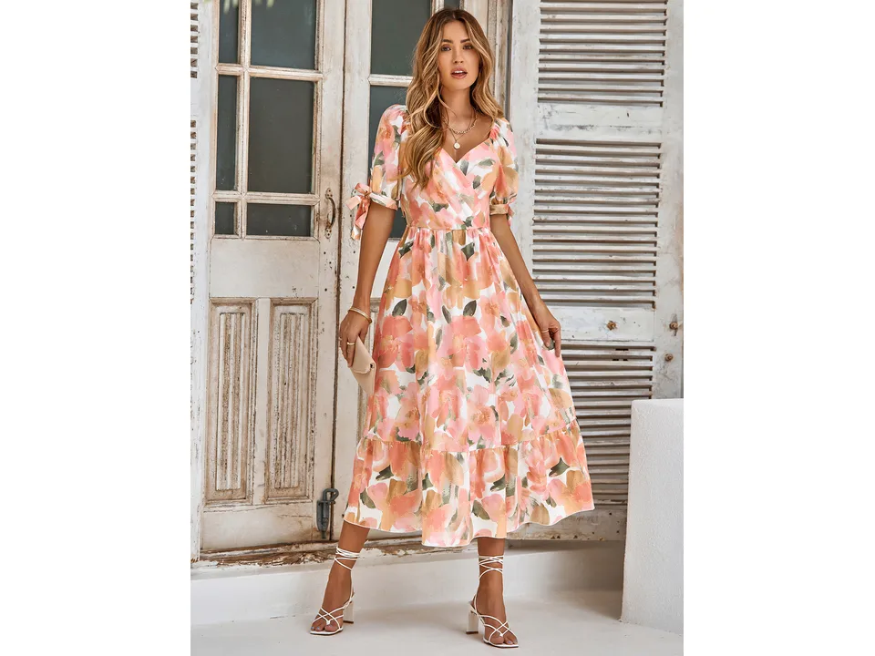 A model wearing the peach and pink floral midi dress with puff sleeves.