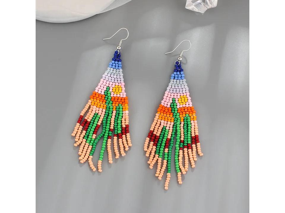 A pair of beaded tassel earrings with a colorful desert landscape design.