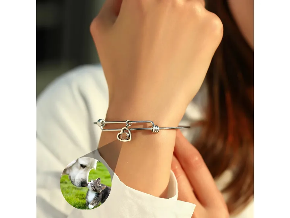 Silver heart-shaped projection bracelet worn on a wrist.