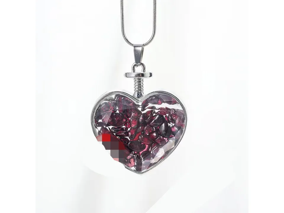 Heart-shaped pendant necklace filled with red crystal gravel on a silver chain.