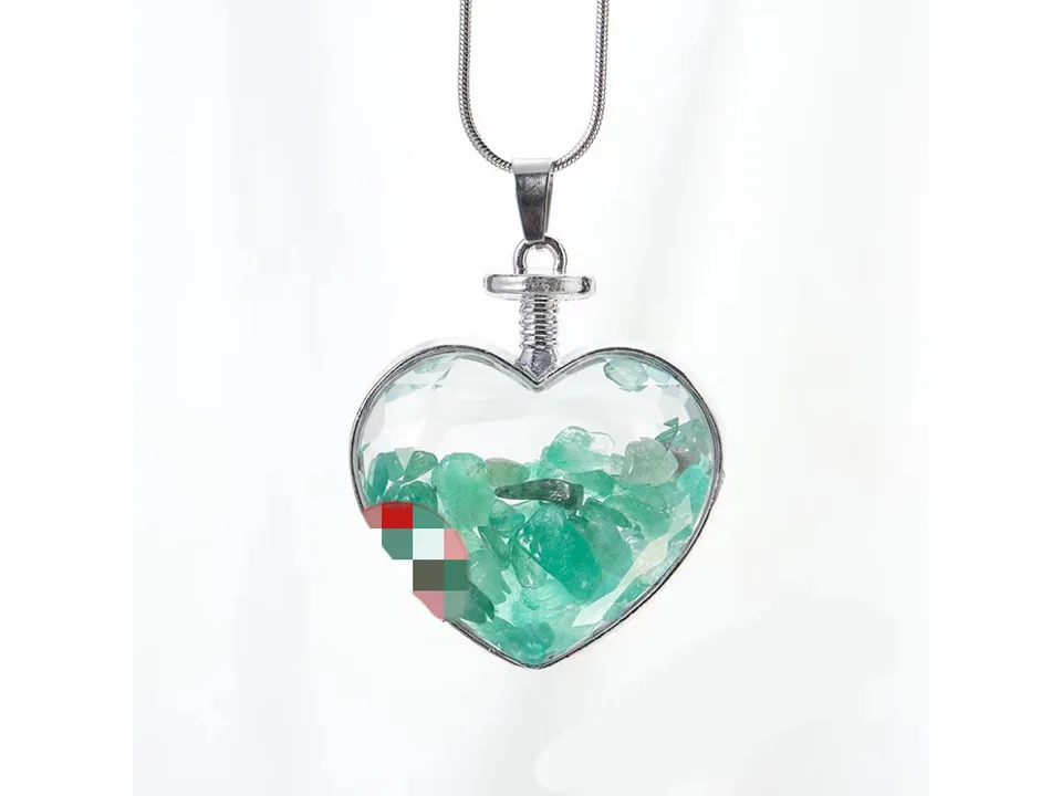 Heart-shaped pendant necklace filled with green crystal gravel on a silver chain.