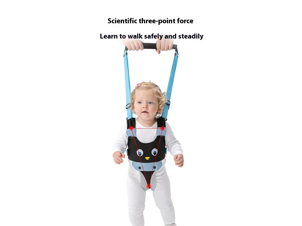A baby wearing a blue and black walking harness, being held by an adult's hands.