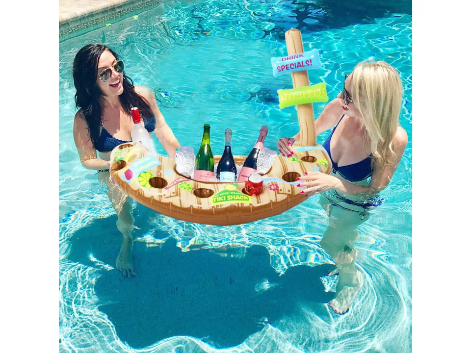 Inflatable tiki-themed pool drink holder floating in a swimming pool with two women.