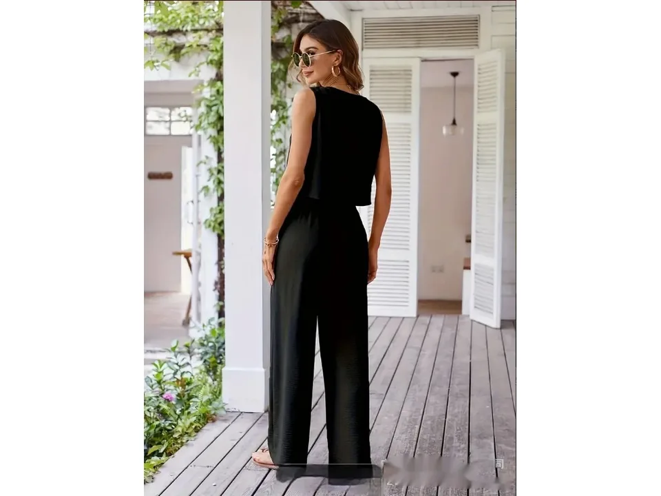 A woman from behind, wearing a black sleeveless vest and matching wide-leg pants.