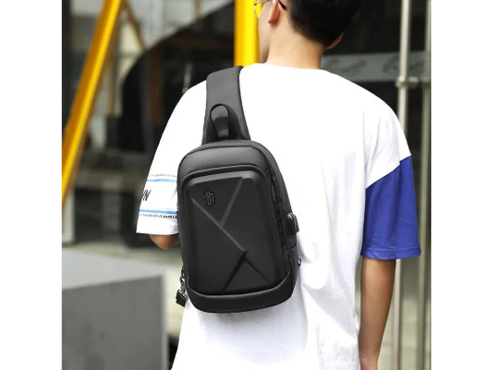 A person wearing the black chest bag on their back.