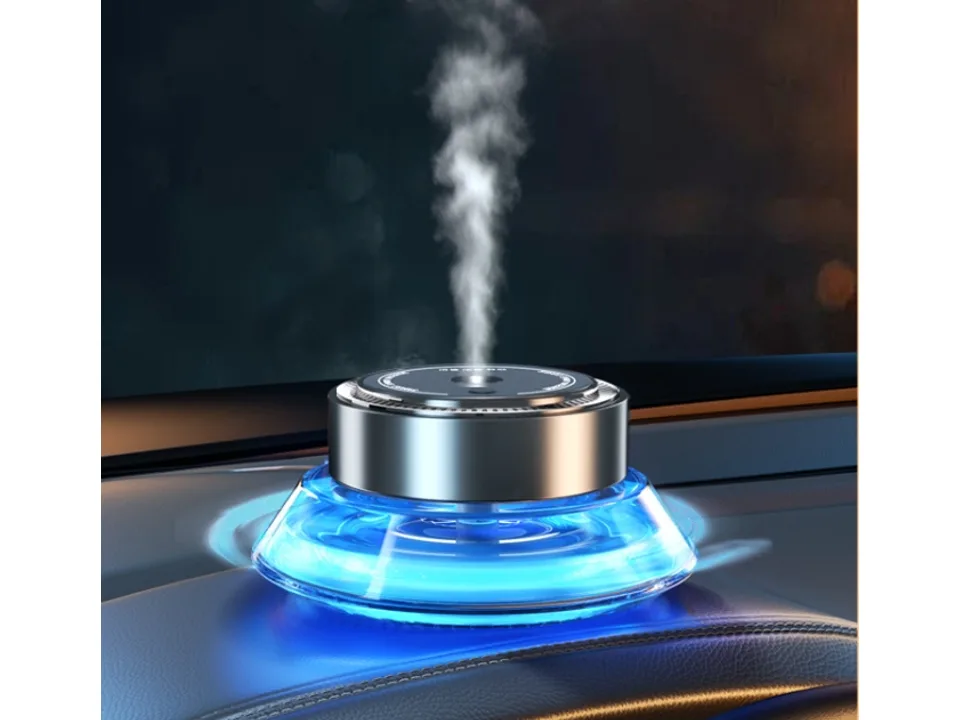 The car aromatherapy diffuser sitting on a dashboard, emitting a visible mist.