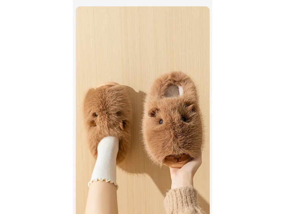 A person wearing one plush slipper while holding the other in their hand.
