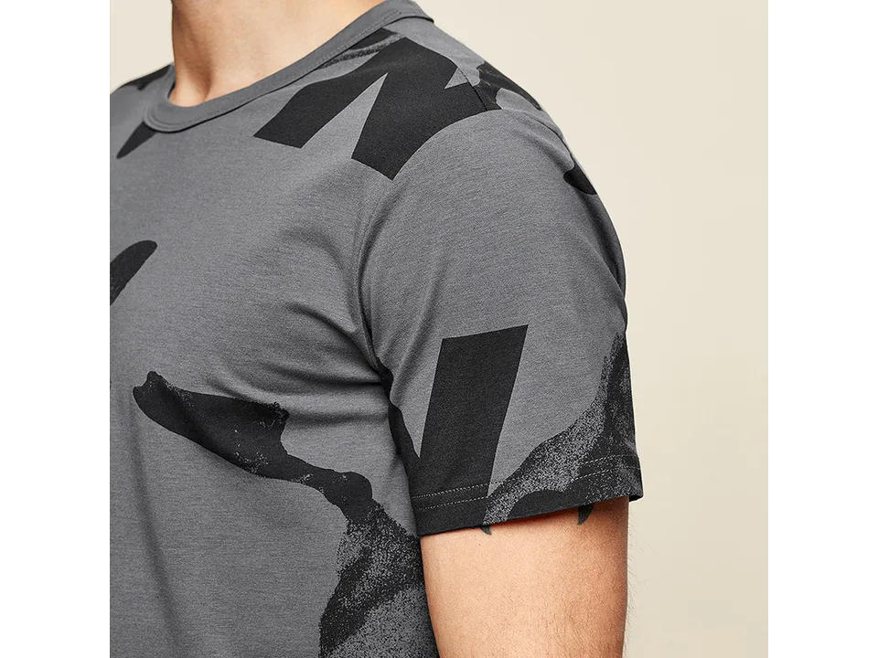 Close-up of the shoulder and sleeve of the grey printed t-shirt.