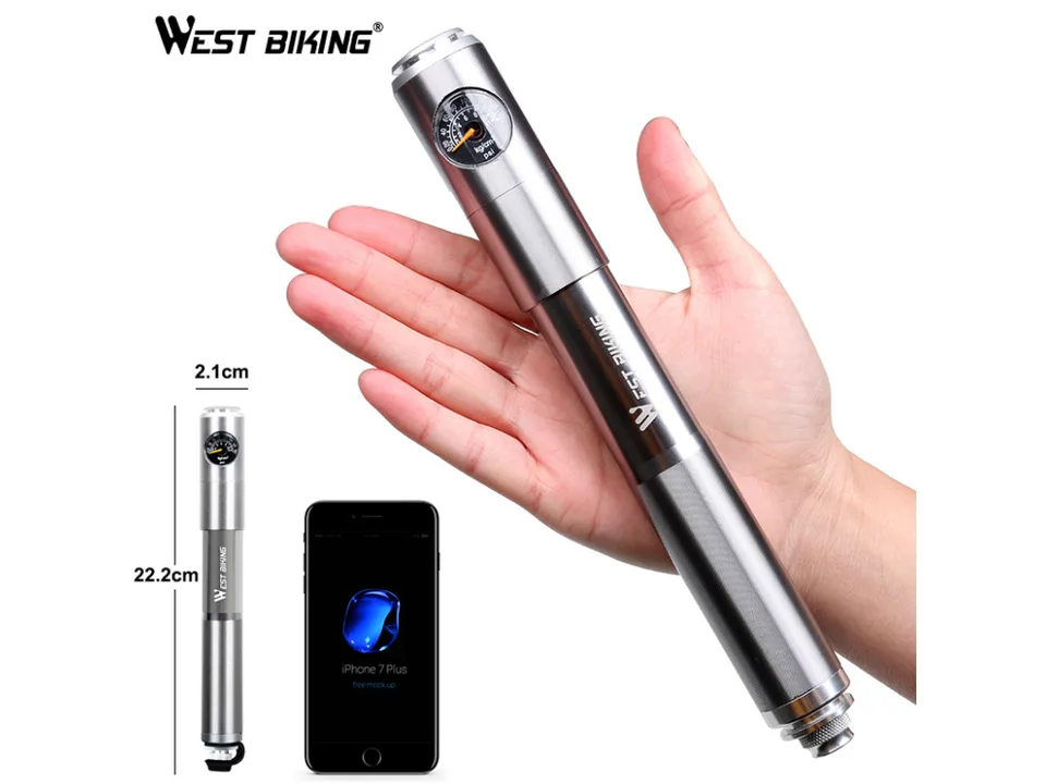 A silver bicycle hand pump held in a hand, showing its size relative to a smartphone.