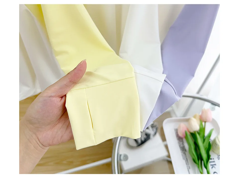 Close-up of a hand holding the sleeve cuff of a sun jacket, showing the thumb hole.