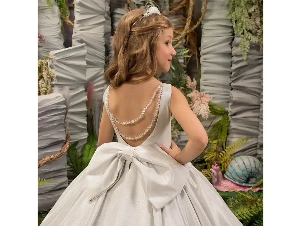Close-up of the back of the dress showing beaded straps and a large bow.