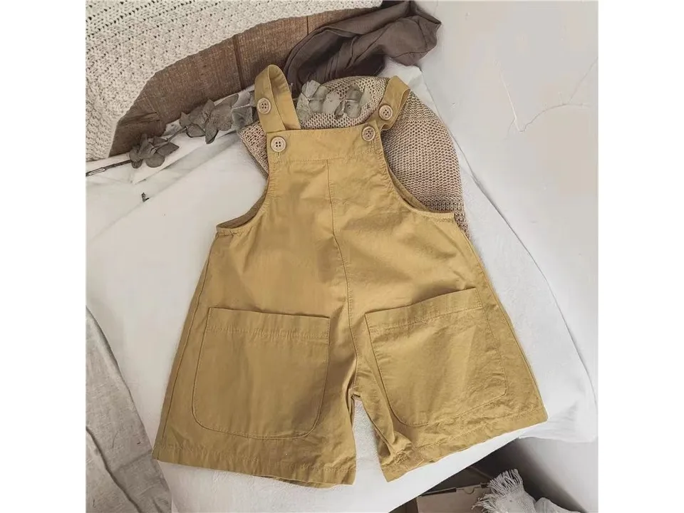 A single pair of yellow baby suspender shorts with front pockets.