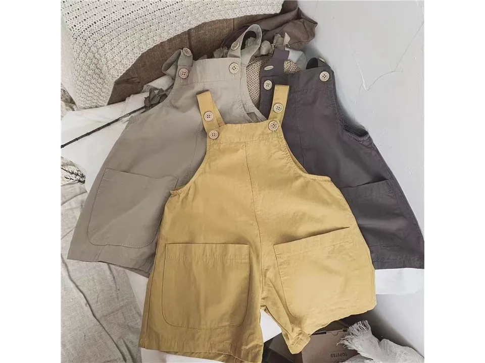 Three pairs of baby suspender shorts showing the front pockets and button straps.