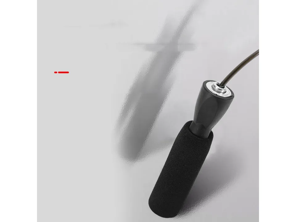 Close-up of the black foam handle and metal connection point of the skipping rope.