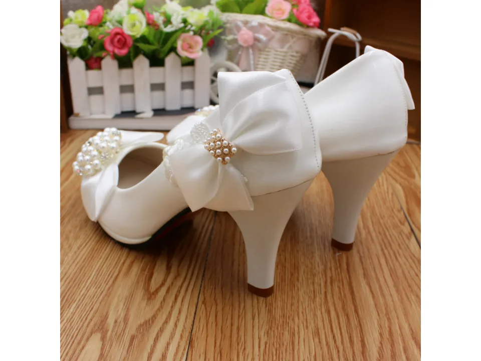 Rear view of white bridal heels showing the heel height and bow detail.