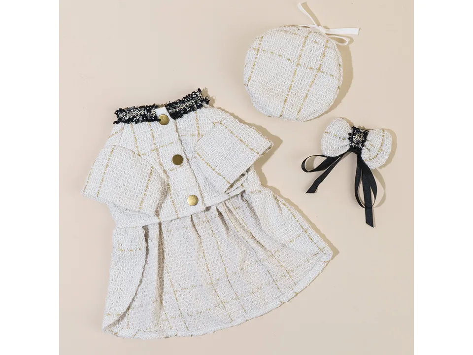 The white tweed coat, hat, and bow tie set laid out together.