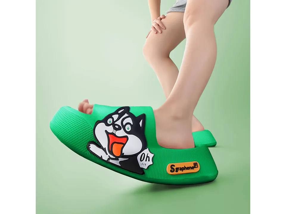 A person wearing a green thick-soled sandal with a cartoon dog design.
