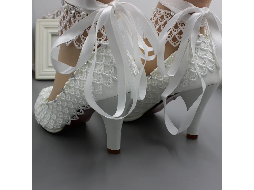 Back view of white lace wedding pumps showing the ribbon tie detail.